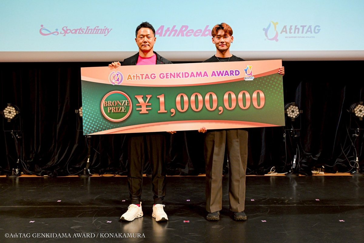 2025年 Bronze Prize の表彰シーン。活動応援費100万円の目録パネルを掲げる受賞者と関係者。
